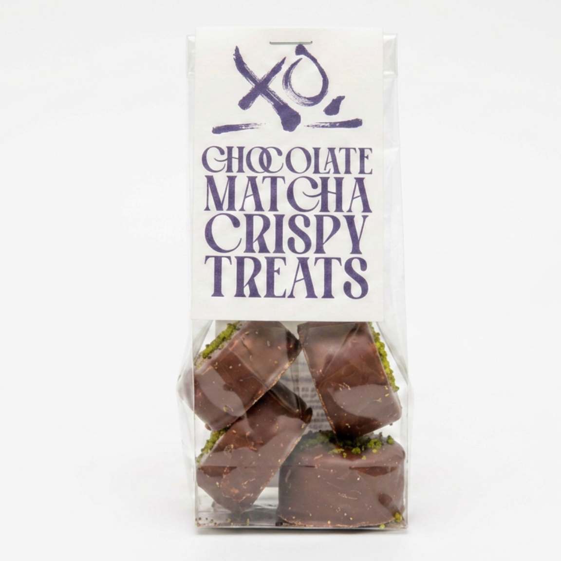 A clear plastic bag of chocolate matcha crispy treats with a white label featuring purple text and a stylized logo, set against a plain white background.